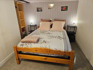 a bedroom with a wooden bed with two pillows at Chambre d'Hôtes le Gachignard in Courlay