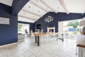 a dining room with blue walls and a table and chairs at Tour Maréchal - Villa d'Exception in LʼHerbergement +42 photos