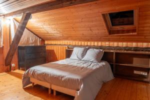 a bedroom with a bed in a wooden cabin at Gite les fans in Prénovel