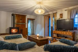 a living room with two couches and a flat screen tv at Gite les fans in Prénovel