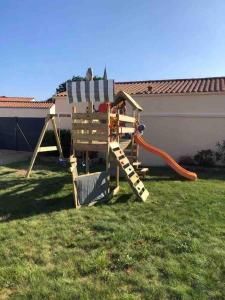 a wooden playground in a yard with at Tour Maréchal - Villa d'Exception in LʼHerbergement