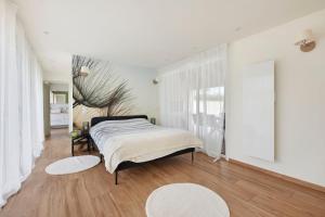 a bedroom with a bed and a large window at Tour Maréchal - Villa d'Exception in LʼHerbergement