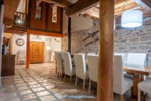 a dining room with a table and white chairs at Gite les fans in Prénovel