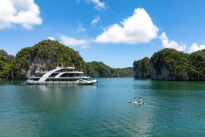 a boat in a body of water with people in a canoe at DUNG LAI HOTEL 173 in Cat Ba