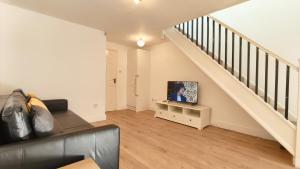 a living room with a tv on a stand in a stair case at Colindale 4 bedroom house with garden and 2 parking spaces in Colindale