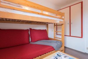 a bedroom with two bunk beds with red pillows at Résidence Pierre & Vacances Les Combes in Les Menuires