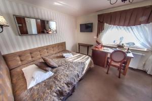 a bedroom with a bed and a desk and a chair at Hotel Fryderyk in Rzeszów