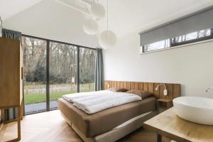 a bedroom with a large bed and a sink at Villa Vechtrijk | 12 persons in Gramsbergen +31 photos