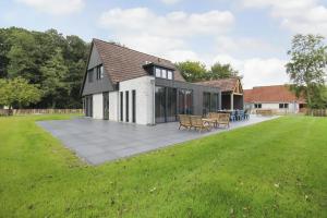 a house with a large patio in the yard at Villa Vechtrijk | 12 persons in Gramsbergen