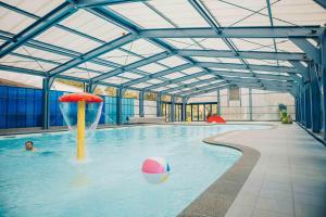 a person in a pool with a ball in the water at Villa Vechtrijk | 12 persons in Gramsbergen