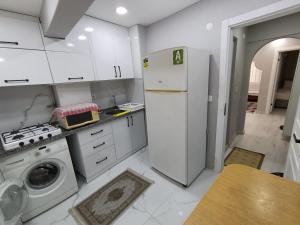 a white kitchen with a refrigerator and a washing machine at BlueRoyal Home Sultanahmet in Istanbul