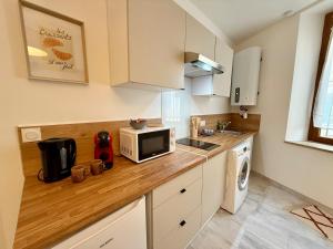 a kitchen with a counter top with a microwave at L'Atrium - Cour intérieure & box vélo, rdc in Castelnaudary +8 photos