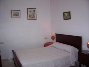 um quarto com uma cama e duas fotografias na parede em Casa Amigo em Castaño de Robledo
