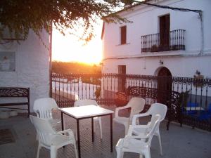 Castaño de RobledoにあるCasa Amigoの夕日を望む建物の前にテーブルと椅子