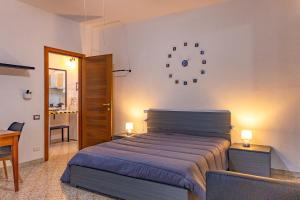 a bedroom with a bed and a desk with two lamps at Casa Grasso in Vittoria