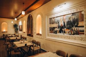 a restaurant with tables and a painting on the wall at Kasr-ı Kikan Hotel in Mardin