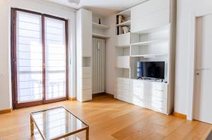 a living room with a tv and a glass table at Aosta Holiday Apartments - Edelweiss in Aosta