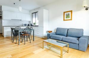 a living room with a blue couch and a table at Aosta Holiday Apartments - Edelweiss in Aosta