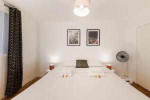 a bedroom with a large white bed in a room at L'Horizon in Noisy-le-Grand