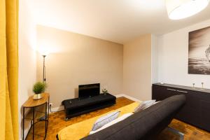a living room with a couch and a television at L'Horizon in Noisy-le-Grand