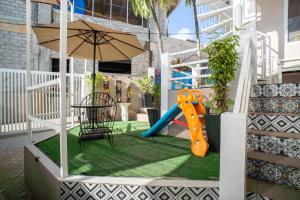 a playground with a slide and an umbrella at Prim Travellers Inn in Coron