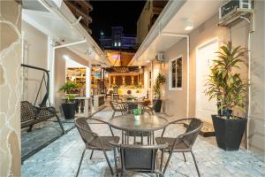 an outdoor patio with tables and chairs and plants at Prim Travellers Inn in Coron