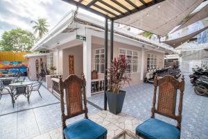 a patio with chairs and tables and a building at Prim Travellers Inn in Coron