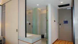 a bathroom with a sink and a mirror at Nusatu by ARTOTEL - Semarang in Semarang +38 photos