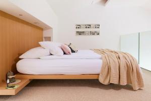 a bedroom with a bed with white sheets and pillows at Villa Alma Vista in Dobrovo