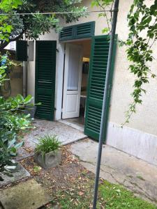 a door with green shutters on a building at Casina Marina in Marina di Pisa