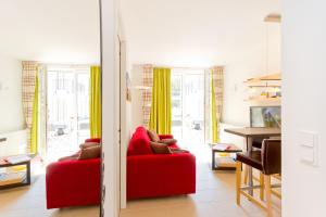 a living room with a red couch and yellow curtains at Meeresblick Fewo Strandnest - in Baabe