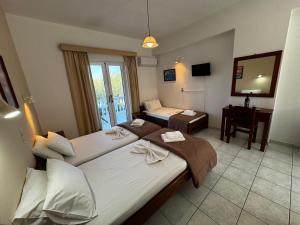 a hotel room with two beds and a desk at Pelagos Studios in Amoudi