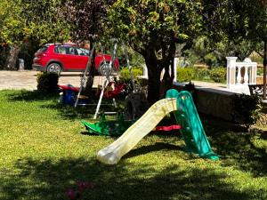 a slide in the grass next to a tree at Pelagos Studios in Amoudi