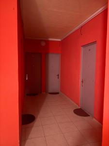 an empty hallway with red walls and white doors at у моря in Itʼkhvisi