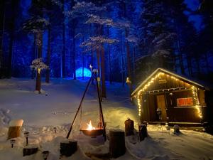 Eine Hütte mit einem Feuer im Schnee bei Nacht in der Unterkunft Beaver Cabin in Mora