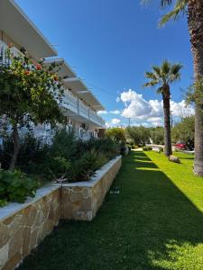 a building with palm trees and a grass yard at Pelagos Studios in Amoudi