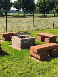a group of picnic tables and benches in a field at Chata U Bezedné in Velký Osek +16 photos