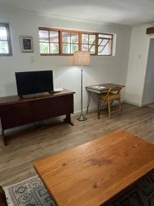 a living room with a flat screen tv and a table at Milburn in Tokai