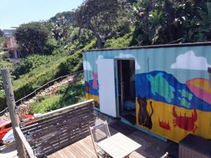 a train car with a table and a chair on a deck at uMkhaKhaya Container Home in Westbrook