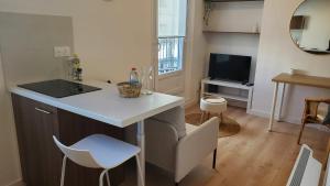 a kitchen with a counter and a living room at Le Balcon Cosy - Centre Clermont in Clermont-Ferrand