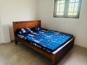 a bed with a blue comforter on it in a room at Matara Villa in Matara
