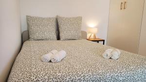 a bedroom with a bed with three towels on it at Le Balcon Cosy - Centre Clermont in Clermont-Ferrand