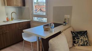 a small kitchen with a table and a couch at Le Balcon Cosy - Centre Clermont in Clermont-Ferrand