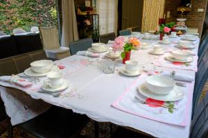 a table with plates and cups and saucers on it at Rozerie BV in Waregem
