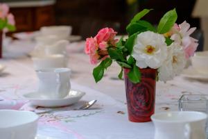 a red vase filled with flowers on a table at Rozerie BV in Waregem