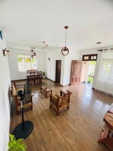 a large living room with wooden floors and chairs at SAN Holiday Villa in Wadduwa