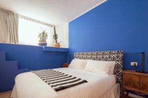 a blue bedroom with a bed with a blue wall at Laguna Boutique Apartments in Mestre