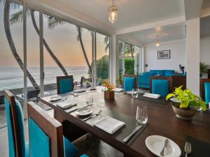 a dining room with a table with a view of the ocean at Florain Otium Talpe in Unawatuna