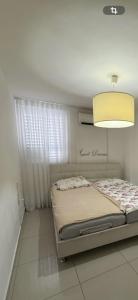 a bedroom with a bed and a chandelier at Luba in H̱olon
