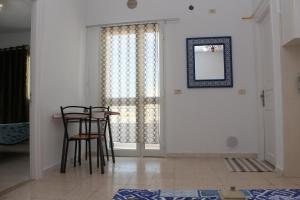 a dining room with a table and chairs and a mirror at Résidence Chahed in Hammam Sousse